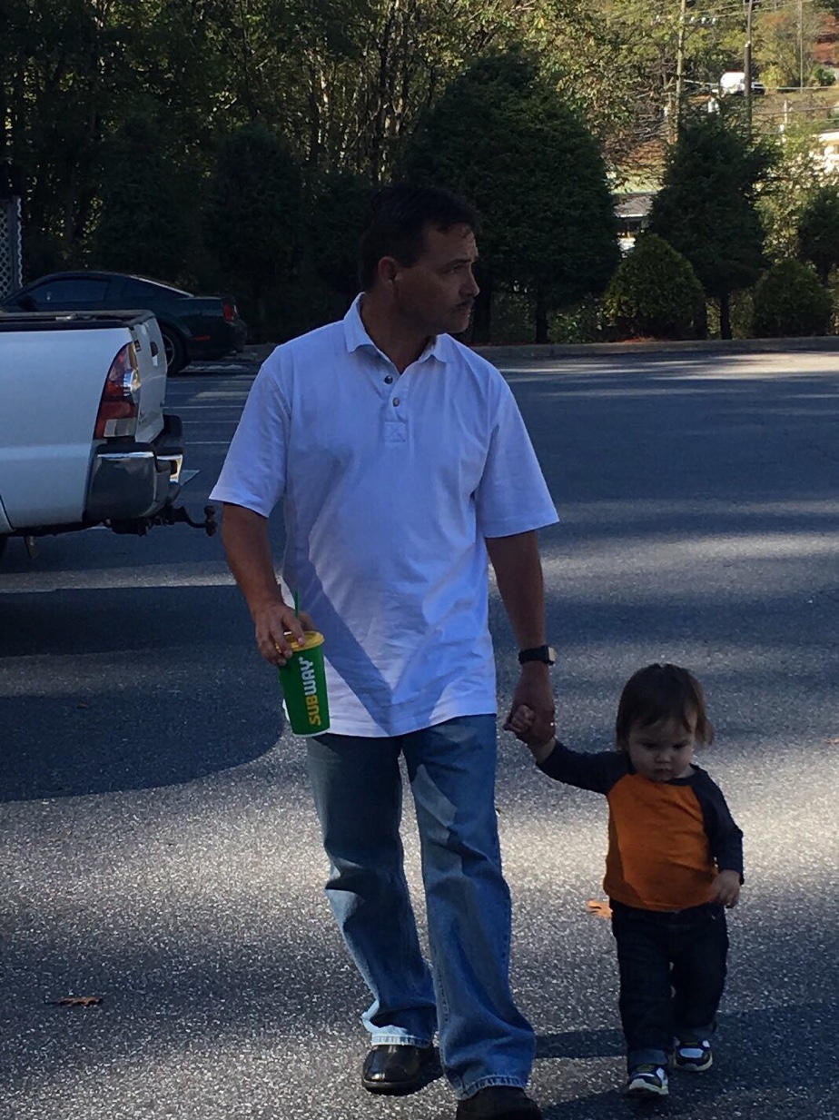 PopPop walking hand-in-hand with toddler Rhett